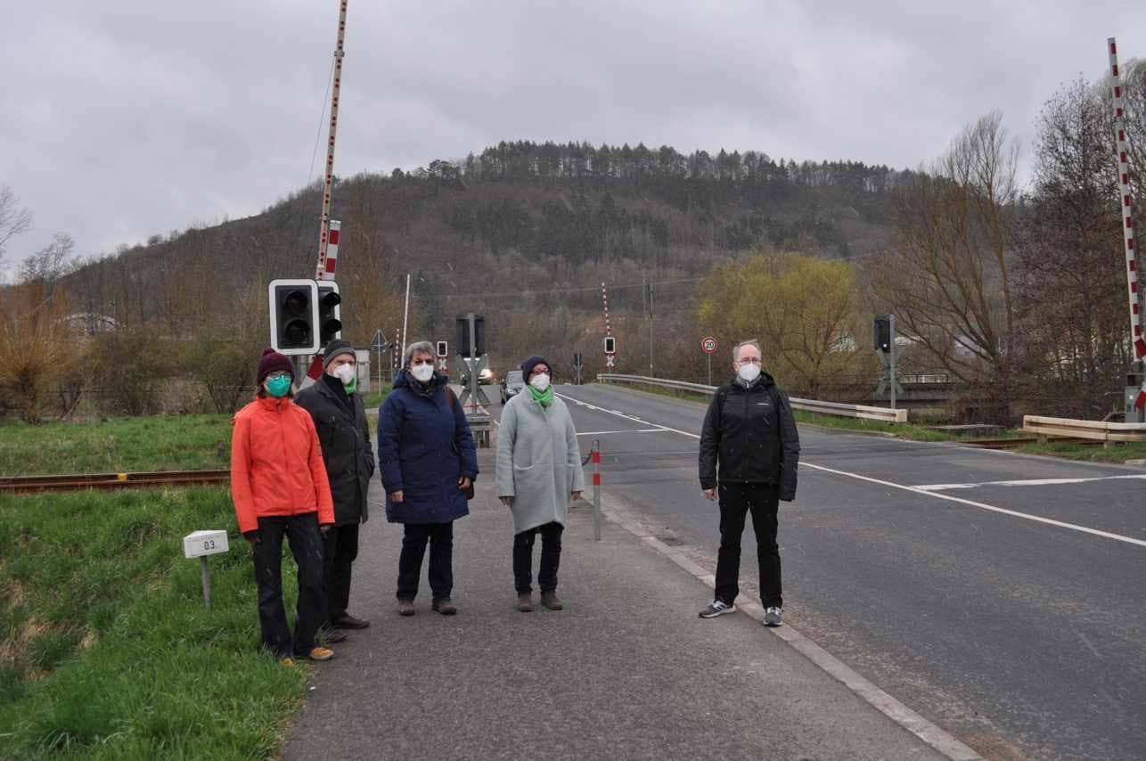 Grünen-Mitglieder vor dem doppelten Bahnübergang in Königshofen