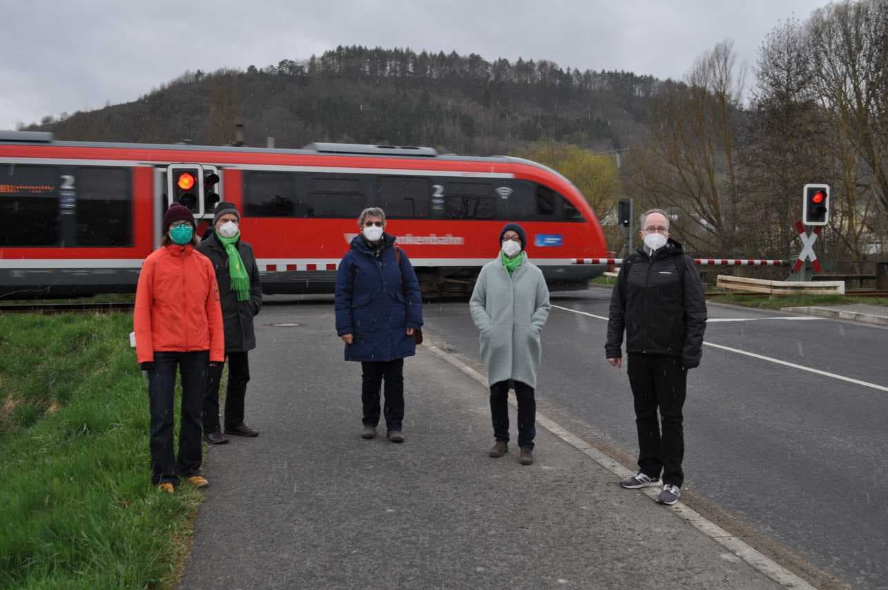 Grünen-Mitglieder vor dem doppelten Bahnübergang Königshofen